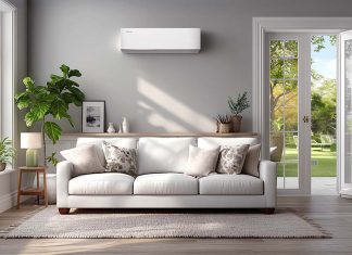Ar Condicionado Eficiente: A gestão do consumo energético em contexto de calor extremo Sala de estar decorada em tons neutros com um ar condicionado eficiente instalado na parede branca sobre o sofá.