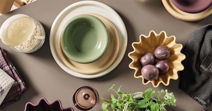 Mesa posta com louça colorida, copos em vidro e acessórios da coleção Nordic Mood da JYSK para decoração de cozinha inspirada no design escandinavo