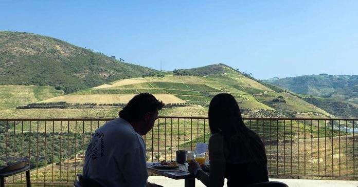 Pequeno-almoço com vista para o Douro Escapadinha no Douro com casal a tomar o pequeno-almoço numa varanda com vista para as vinhas