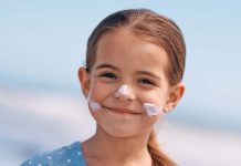 Proteção solar infantil: cuidados essenciais para proteger a pele das crianças no verão Proteção solar infantil aplicada no rosto de uma criança durante um dia de verão para proteger a pele dos raios UV.