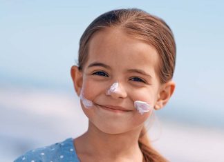 Proteção solar infantil: cuidados essenciais para proteger a pele das crianças no verão Proteção solar infantil aplicada no rosto de uma criança durante um dia de verão para proteger a pele dos raios UV.