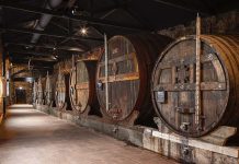Caves de vinho do Porto: nova experiência museológica chega às Caves Burmester Interior das caves de vinho do Porto da Burmester, em Vila Nova de Gaia, com balseiros históricos de envelhecimento