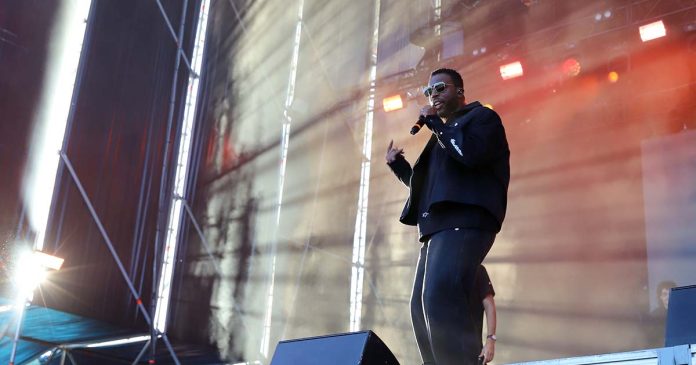 Dino d'Santiago em palco a cantar sob iluminação cénica e efeitos de luz no MEO Kalorama