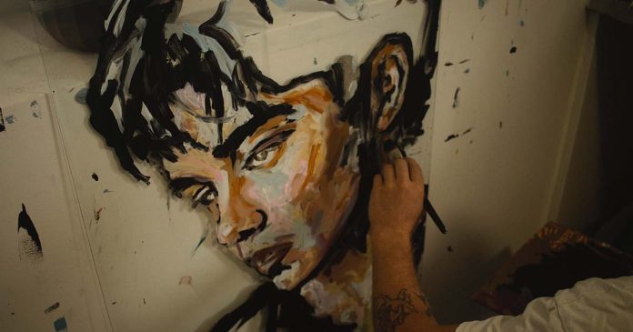 Artista pinta retrato para a exposição de arte de Chris Bugge