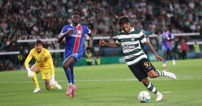 No jogo entre o Sporting e o Alverca, o avançado Luis Suárez conduz a bola sob a pressão de um defesa adversário.