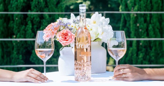 Garrafa de Pacheca Trésor, vinho rosé do Dão, entre dois copos e flores numa mesa