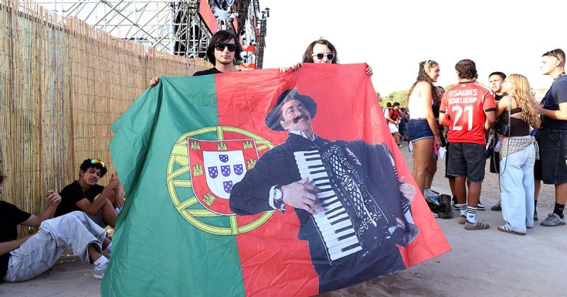 &Uacute;ltimo dia do Sol da Caparica com p&uacute;blico a segurar bandeira portuguesa com imagem de Quim Barreiros