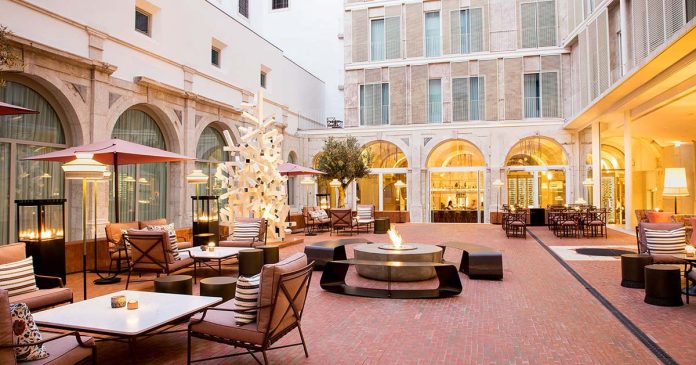 Claustro do Convent Square Lisbon Hotel com arcos de pedra e zonas de estar