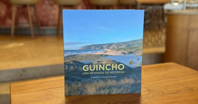 Livro «Guincho: Uma Revoada de Histórias», sobre a história do Guincho, em pé numa mesa de madeira