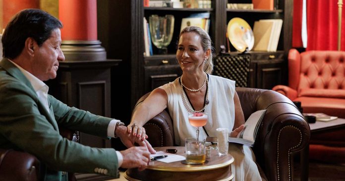 Joaquim de Almeida e uma mulher sentados à mesa numa cena do filme promocional do MYTHIC SANA