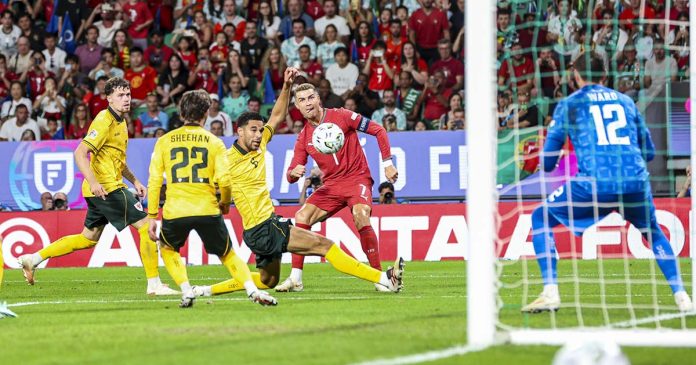 Portugal - Gales: Cristiano Ronaldo disputa a bola na área, diante dos defesas galeses e do guarda-redes Danny Ward
