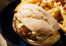 Prego de Hambúrguer põe um Parafuso no clássico da Portugália Prego de Hambúrguer da Portugália servido em pão com queijo, cebolada e molho, acompanhado por batatas fritas