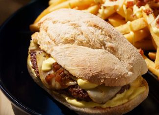 Prego de Hambúrguer põe um Parafuso no clássico da Portugália Prego de Hambúrguer da Portugália servido em pão com queijo, cebolada e molho, acompanhado por batatas fritas