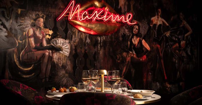 Programação do Maxime numa sala com decoração de cabaret e mesa preparada no espaço lisboeta