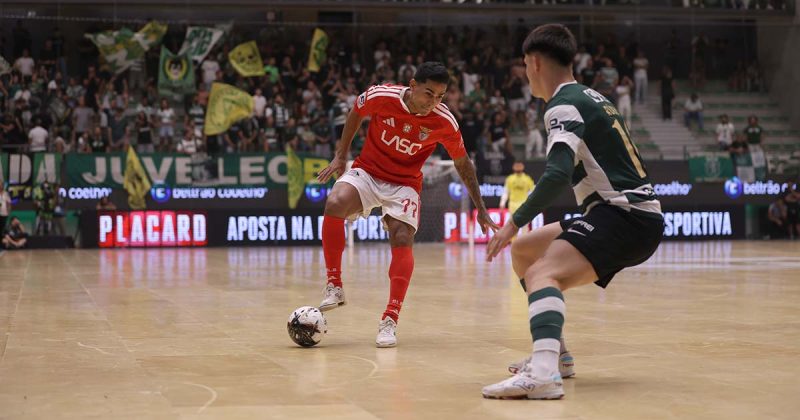 Sporting-Benfica em futsal: jogador do Benfica conduz a bola diante de um jogador do Sporting no Pavilh&atilde;o Jo&atilde;o Rocha