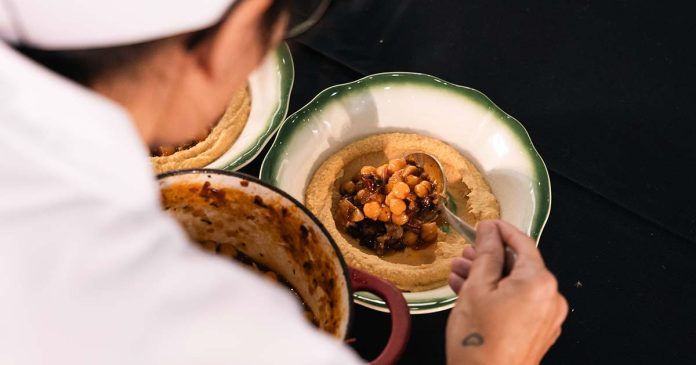 Chef prepara o empratamento de uma receita durante uma prova de cozinha do Troféu Portugal