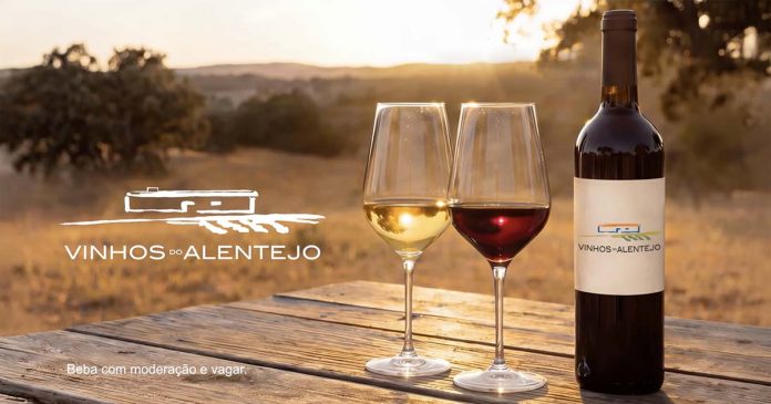 Vinhos alentejanos com garrafa e copos de vinho numa paisagem do Alentejo