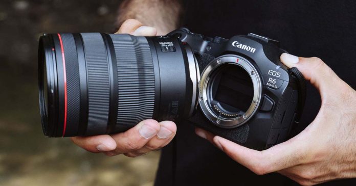 Canon EOS R6 Mark III e objetiva Canon RF seguradas por um fotógrafo, com o encaixe da câmara visível