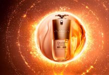Cuidados de beleza Clarins aplicam a ciência da pele ao rosto e ao cabelo Frasco de Double Serum Foundation sobre fundo dourado, em destaque nos cuidados de beleza Clarins