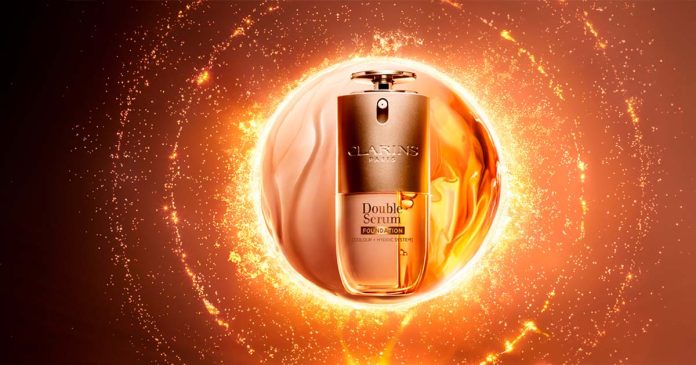 Frasco de Double Serum Foundation sobre fundo dourado, em destaque nos cuidados de beleza Clarins