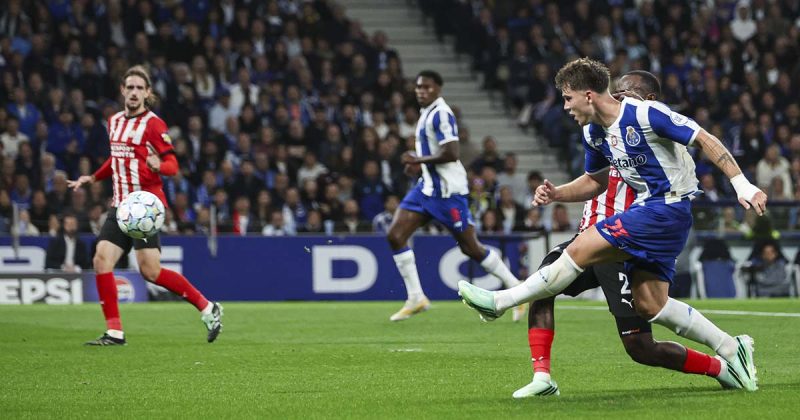 Jogador portista remata sob press&atilde;o de um advers&aacute;rio no encontro entre FC Porto e PSV, no Est&aacute;dio do Drag&atilde;o