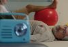 Filme de Nuno Markl leva ao cinema “O Homem Que Mordeu o Cão” Cena do filme de Nuno Markl com um homem deitado numa marquesa e um rádio azul em primeiro plano