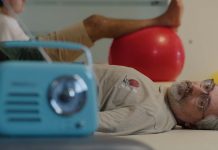 Filme de Nuno Markl leva ao cinema “O Homem Que Mordeu o Cão” Cena do filme de Nuno Markl com um homem deitado numa marquesa e um rádio azul em primeiro plano