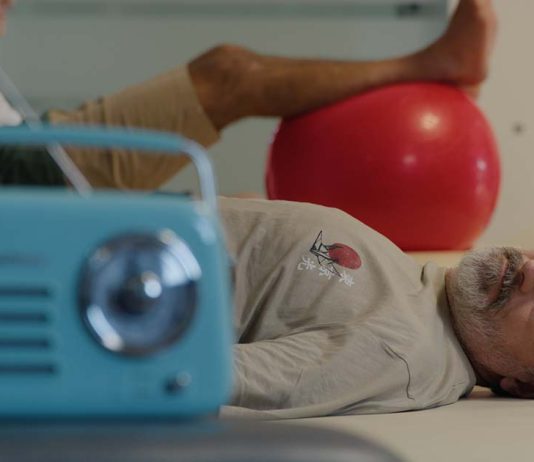 Filme de Nuno Markl leva ao cinema “O Homem Que Mordeu o Cão” Cena do filme de Nuno Markl com um homem deitado numa marquesa e um rádio azul em primeiro plano