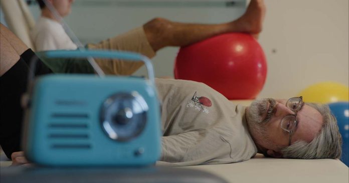 Cena do filme de Nuno Markl com um homem deitado numa marquesa e um rádio azul em primeiro plano