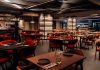 Grelhados no 550º ganham novos contrastes na cozinha de David Casaca Sala com mesas de madeira, cadeiras em tons quentes e bar ao fundo, onde são servidos os grelhados no 550º, em Lisboa