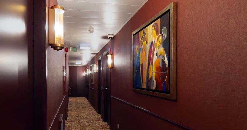 Hotel Olympia Lisboa com corredor decorado com refer&ecirc;ncias art&iacute;sticas junto aos quartos