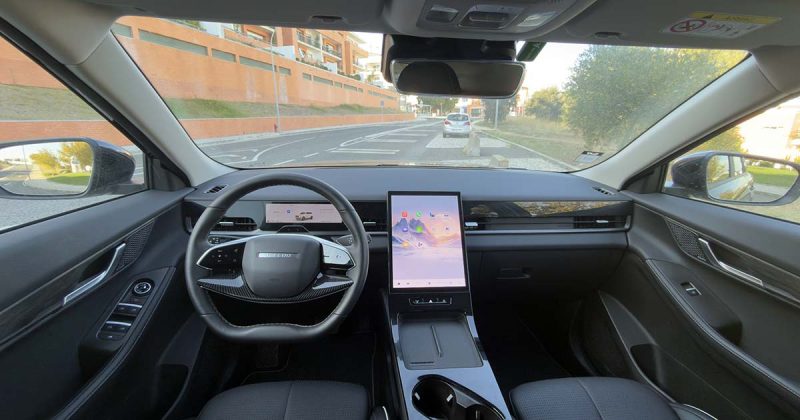 Interior do Jaecoo 5 HEV Exclusive com volante, painel de instrumentos digital e ecr&atilde; central de 13,2 polegadas