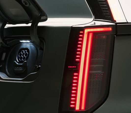 Novo Volvo EX60 regista a menor pegada de carbono de sempre na marca Novo Volvo EX60 com a tampa da porta de carregamento aberta junto ao farolim traseiro