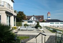Restaurantes do Farol Hotel prolongam os sabores de verão com o outono à mesa Terraço junto aos restaurantes do Farol Hotel, com espreguiçadeiras, vista para o mar e um farol ao fundo
