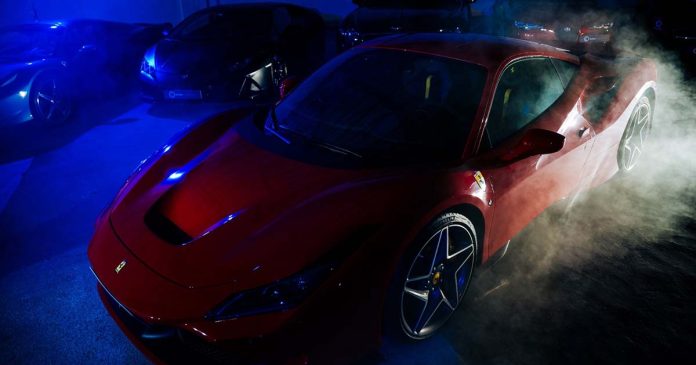 Ferrari vermelho em destaque numa apresentação de automóveis da Rodda Collection
