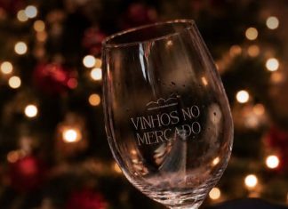 Vinhos no Mercado junta mais de 30 produtores no Porto entre provas e arte Copo Vinhos no Mercado com decoração natalícia ao fundo, no ambiente do evento.